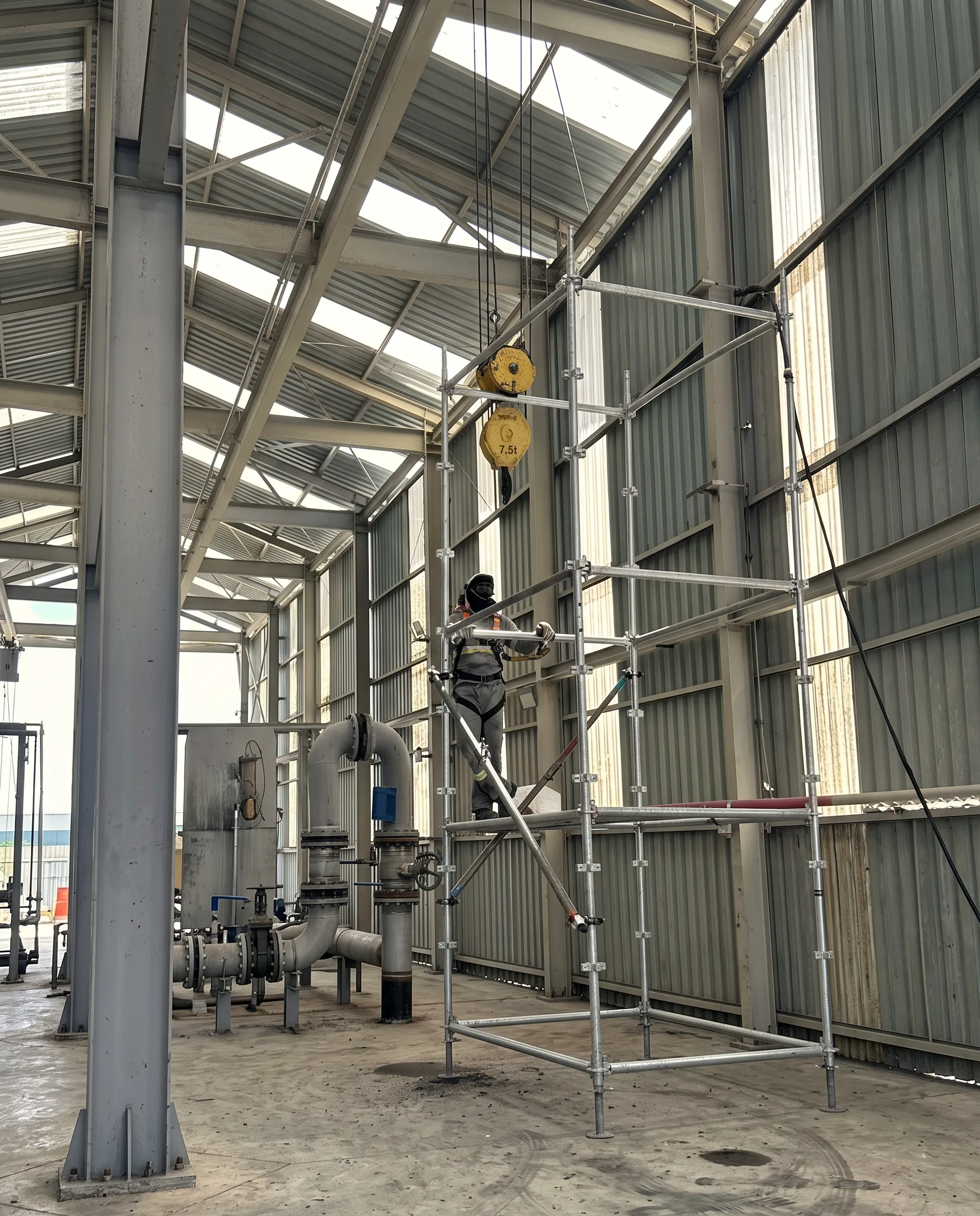 Profissional da RB executando serviço em estrutura metálica dentro de galpão industrial