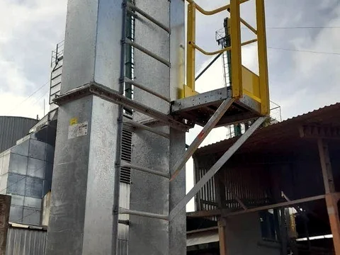Elevador de canecas montado junto a estrutura de silo