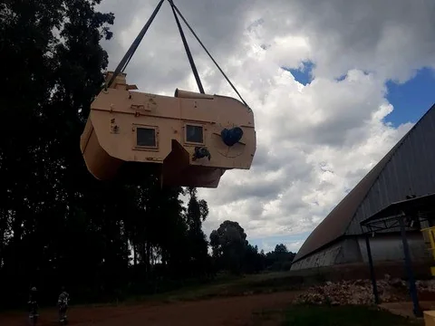 Equipamento industrial içado por guindaste durante montagem